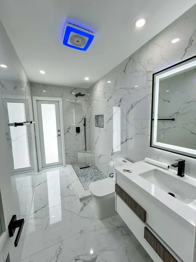 Remodeled guest bathroom with white marble-look porcelain, curbless walk-in shower and LED mirror